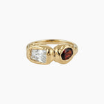 Solid gold sculptural ring featuring a clear rectangular stone and a round deep brown gemstone set in an organic molten-style band. Designed for women seeking a modern statement ring that balances structure and softness, ideal for everyday wear or special occasions and for those wanting a distinctive alternative to traditional gemstone rings.