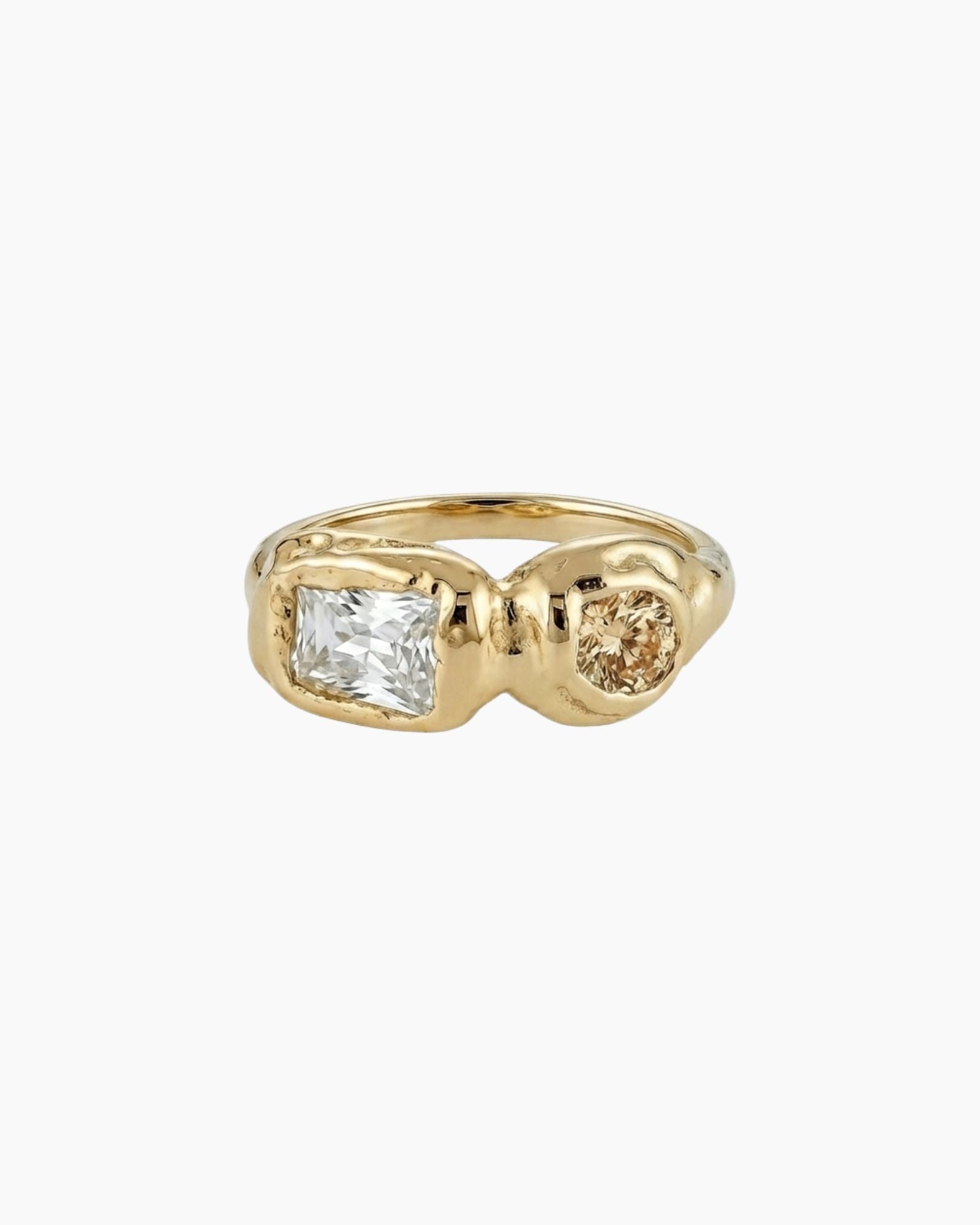 Solid gold sculptural ring with a clear rectangular stone paired with a round champagne-coloured gemstone in an asymmetrical organic setting. Created for women who want a refined yet contemporary statement ring, offering warmth, individuality, and a modern alternative to classic diamond styles.