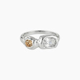 Sterling silver sculptural ring featuring a clear rectangular stone and a round champagne-coloured gemstone in an asymmetrical molten-style band. Designed for women who prefer modern silver jewellery with warmth and depth, offering a unique alternative to minimalist silver rings.