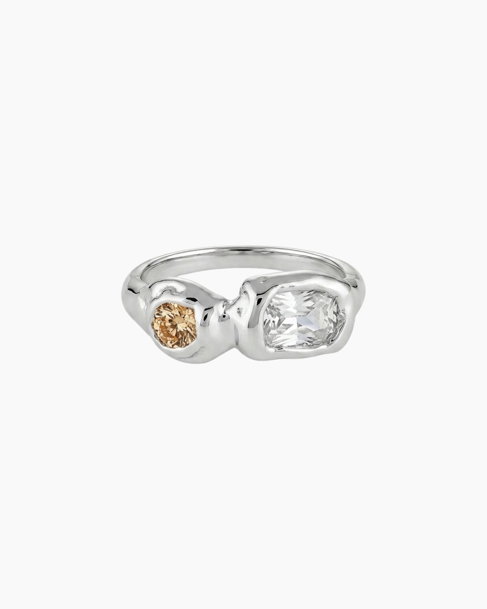 Sterling silver sculptural ring featuring a clear rectangular stone and a round champagne-coloured gemstone in an asymmetrical molten-style band. Designed for women who prefer modern silver jewellery with warmth and depth, offering a unique alternative to minimalist silver rings.