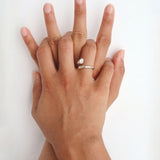 Close-up of a hand wearing the Celine silver open ring with a white cubic zirconia stone against a clean white background. Perfect for women who prefer minimal silver jewellery, this stainless steel ring adds a soft sparkle and helps create an effortless everyday ring stack.