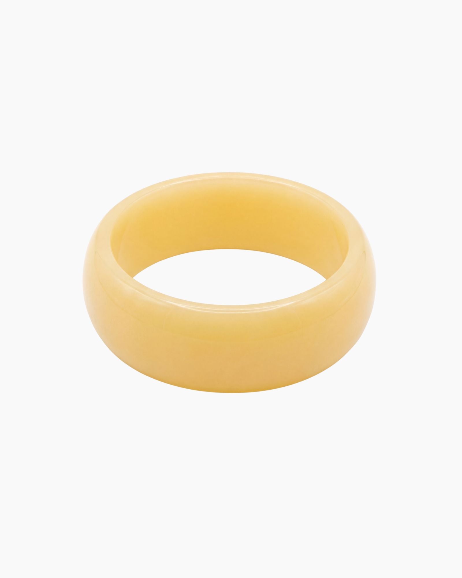 Chunky butter yellow resin bangle with a glossy polished finish. The Lumi Resin Bangle is a modern statement bracelet designed for effortless everyday styling, capsule wardrobes, minimal fashion, and elevated neutral outfits.