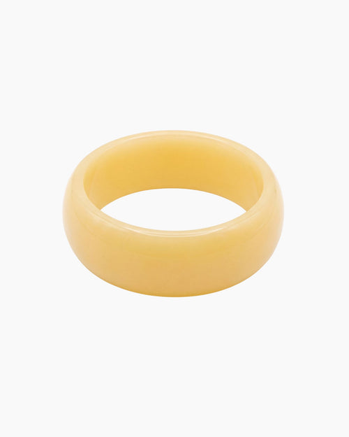 Chunky butter yellow resin bangle with a glossy polished finish. The Lumi Resin Bangle is a modern statement bracelet designed for effortless everyday styling, capsule wardrobes, minimal fashion, and elevated neutral outfits.
