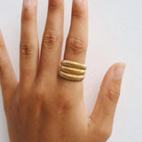 Dara gold ribbed statement ring worn on the finger, showing the chunky layered design for customers wanting a comfortable stainless steel statement ring for everyday styling and jewellery stacking.