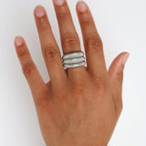Dara silver ribbed statement ring worn on the finger, showing the wide sculptural shape for shoppers looking for a durable stainless steel ring that is easy to style day or night.