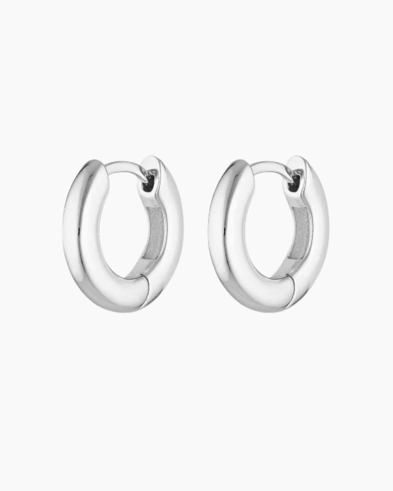 Pair of polished silver hoop earrings displayed on a white background, featuring a chunky rounded profile with a hinged clasp closure. Designed for women seeking everyday silver hoop earrings that are secure, comfortable, and easy to style, these minimalist hoops provide a timeless solution for elevating daily outfits with durable sterling silver jewellery suitable for work, casual wear, and layering with other silver earrings.