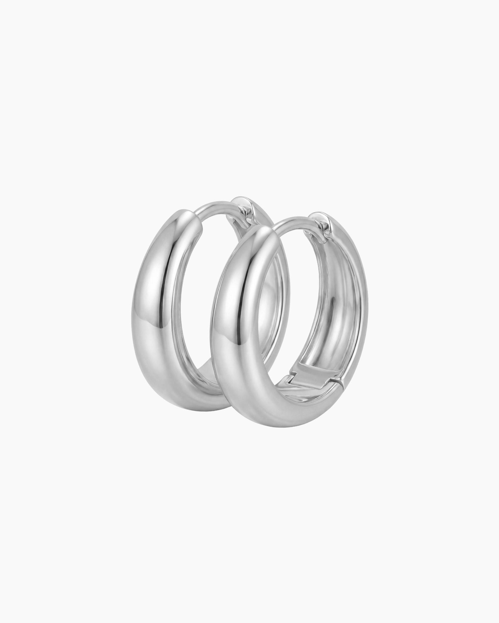 SELENE rounded silver hoop earrings on a white background with a polished chunky dome design. Sterling silver hoop earrings with rhodium plating, designed for comfortable everyday wear, sensitive ears, minimalist styling and classic layered jewellery looks.
