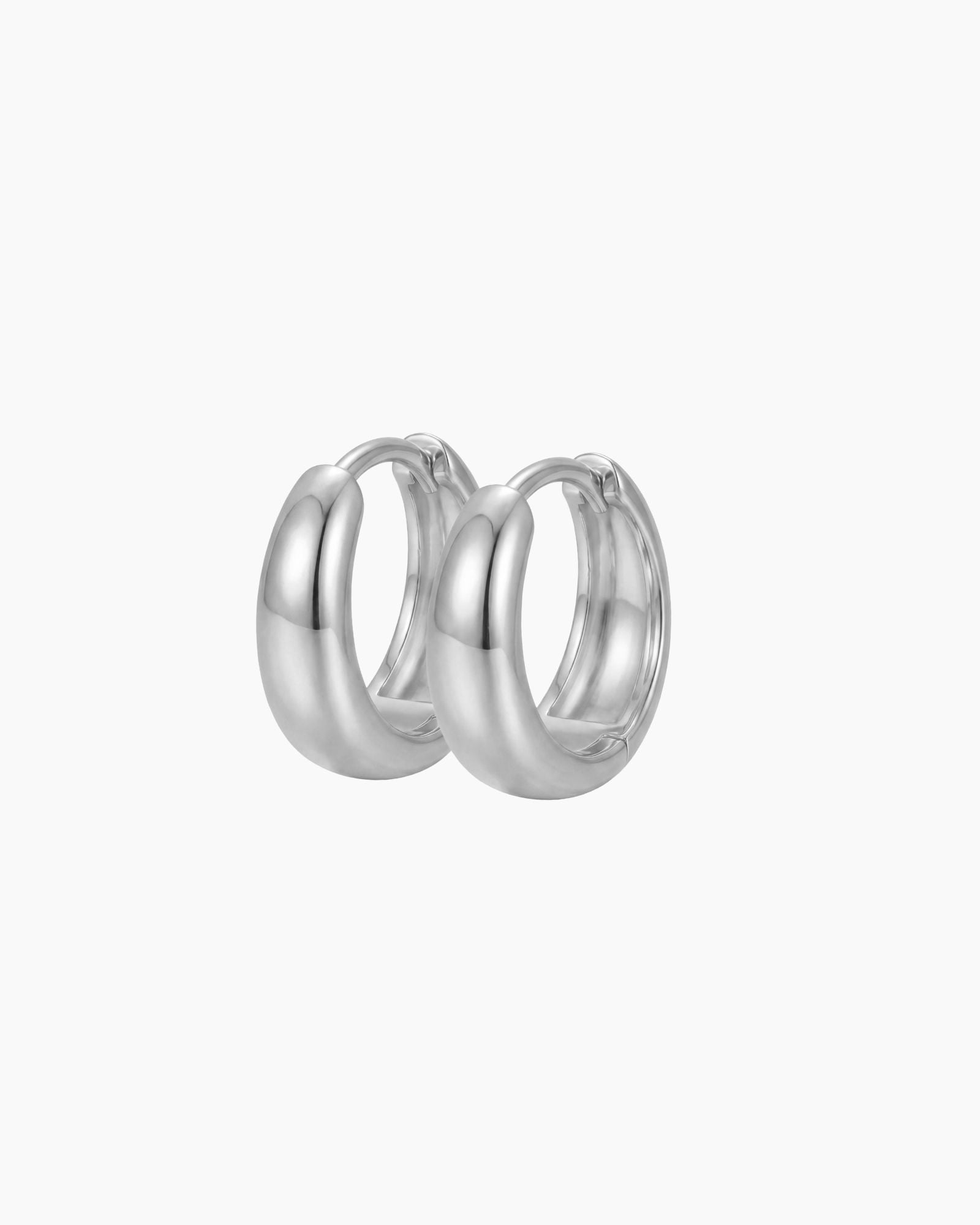 SELENE rounded silver hoop earrings on a white background featuring a polished chunky dome silhouette. Sterling silver hoop earrings with rhodium plating, perfect for everyday wear, sensitive ears, minimalist jewellery styling and layered hoop looks.