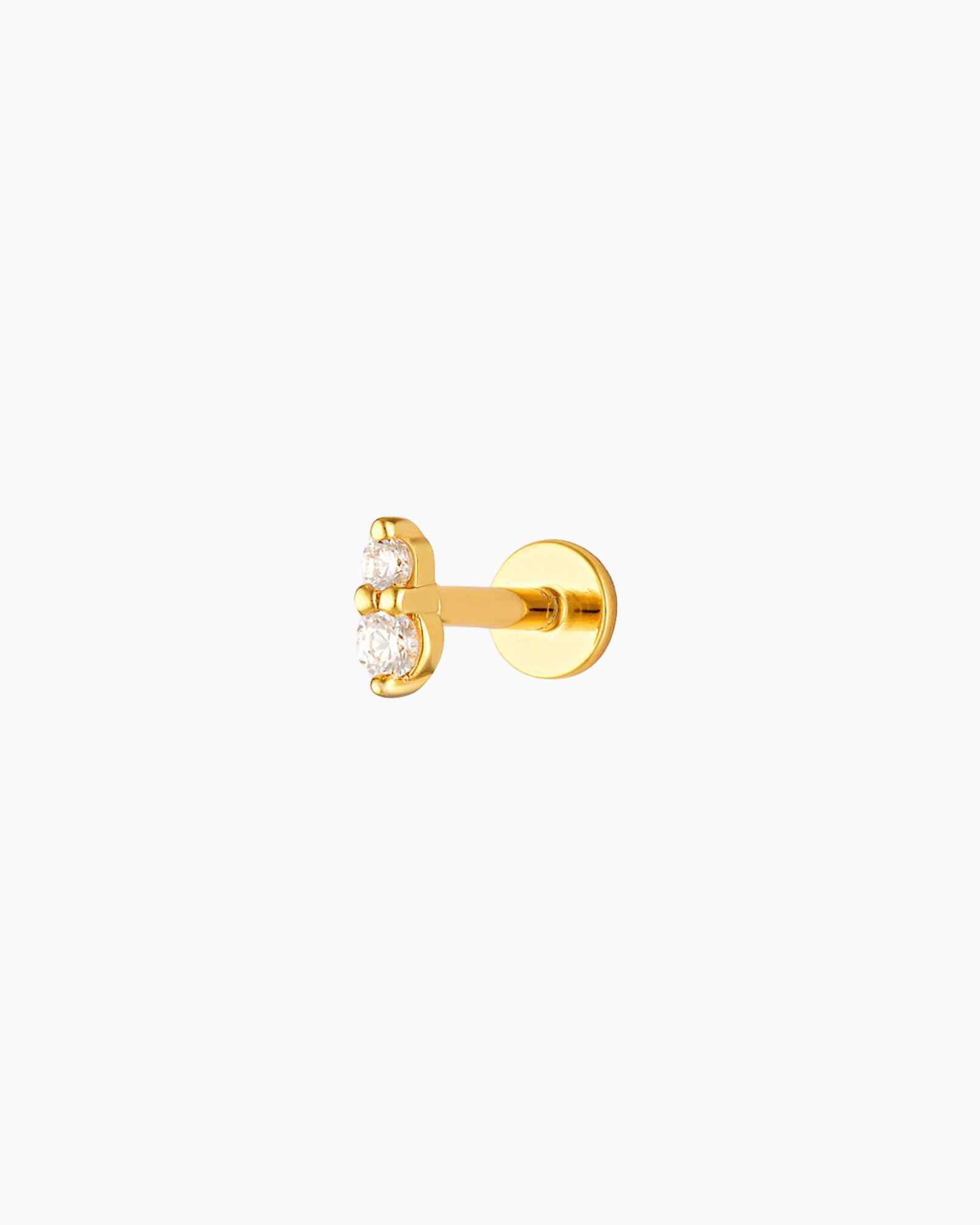 A single gold-plated flat back stud earrings with clear crystal embellishments designed for cartilage piercings.