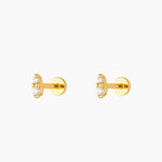 A pair of gold-colored earrings with white crystal studs, displayed against a white background.