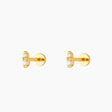 A pair of gold-colored earrings with white crystal studs, displayed against a white background.