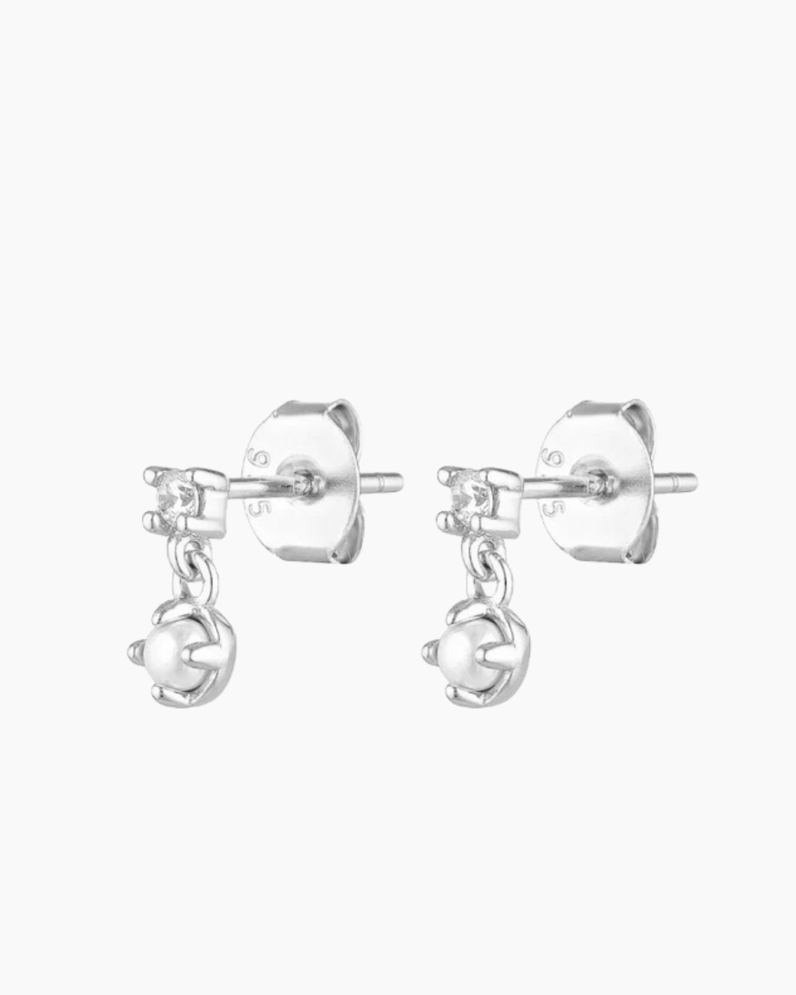 Close-up product image of silver pearl and crystal stud earrings, featuring a small cubic zirconia stud with a dangling freshwater pearl charm on a sterling silver base. Designed for women seeking elegant silver stud earrings for everyday wear, weddings, or special occasions, this image highlights hypoallergenic pearl earrings that offer a refined, lightweight option for sensitive ears, first or second piercings, and minimalist jewellery styling.