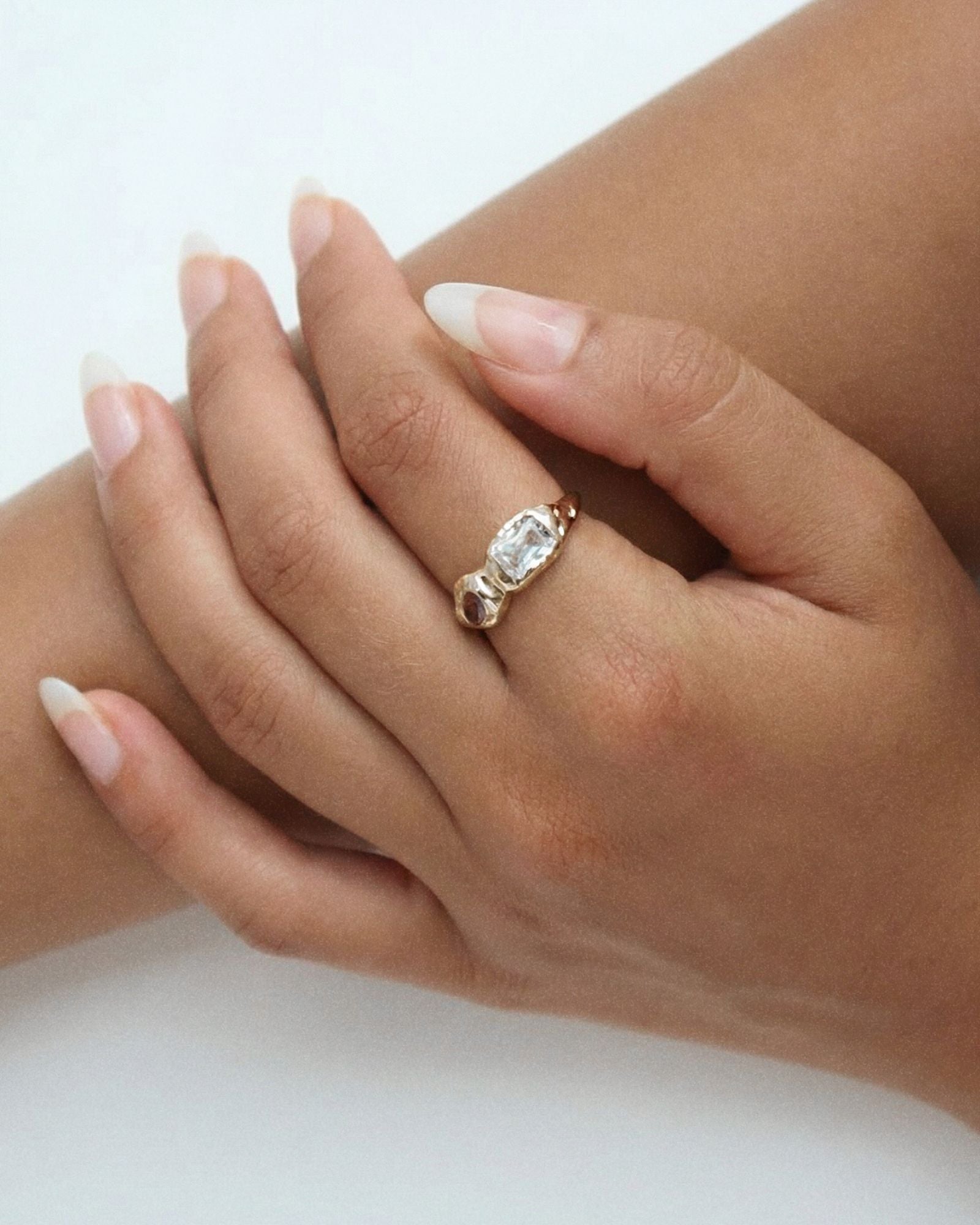 Gold sculptural gemstone ring worn on a woman’s hand, showing scale, fit, and organic band shape in real wear. Ideal for customers wanting to visualise how the ring sits on the finger and how the statement design looks styled naturally on the hand.