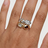 Close-up of silver and gold sculptural gemstone rings worn together, highlighting the contrast between metals, stone colours, and organic settings. Designed to assist customers in choosing between gold or silver and understanding how the rings layer for a bold yet cohesive look.