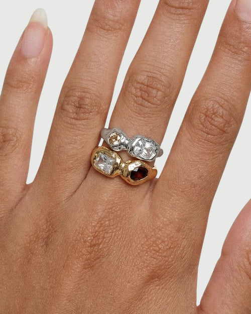 Close-up of silver and gold sculptural gemstone rings worn together, highlighting the contrast between metals, stone colours, and organic settings. Designed to assist customers in choosing between gold or silver and understanding how the rings layer for a bold yet cohesive look.