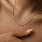 Close-up of a model wearing the Arlo gold filled curb chain necklace, a delicate everyday chain styled alone on the collarbone for a minimal layered jewellery look.