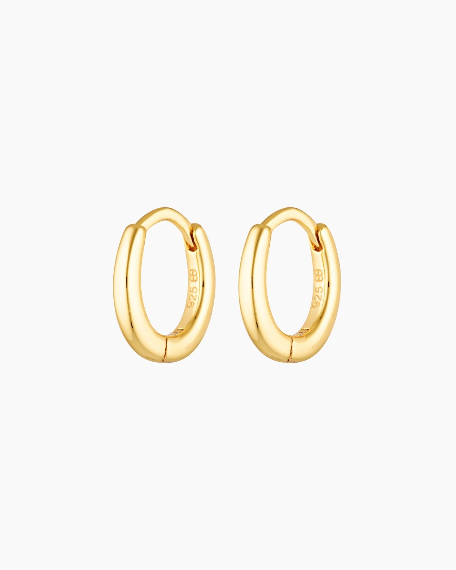 Product image of a pair of small gold huggie hoop earrings with a softly oval shape and a smooth polished finish, crafted from sterling silver with 18k gold plating. Shown on a clean white background, these minimalist gold hoops are designed for women seeking everyday hoop earrings that are lightweight, comfortable, and suitable for sensitive ears, offering a versatile solution for daily wear, ear stacking, and a refined, timeless jewellery look.