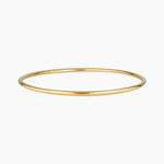 Minimalist slim gold bangle bracelet photographed on a white background, featuring a smooth polished finish. Designed for women seeking a timeless everyday gold bracelet that layers easily with other bangles or can be worn alone for a clean, understated look. Ideal for those looking for durable, low-maintenance gold jewellery that is water safe, lightweight, and suitable for daily wear.