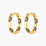 A pair of gold plated hoop earrings adorned with blue and yellow cubic zirconia stones in a floral pattern.