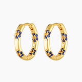 A pair of gold plated hoop earrings adorned with blue and yellow cubic zirconia stones in a floral pattern.