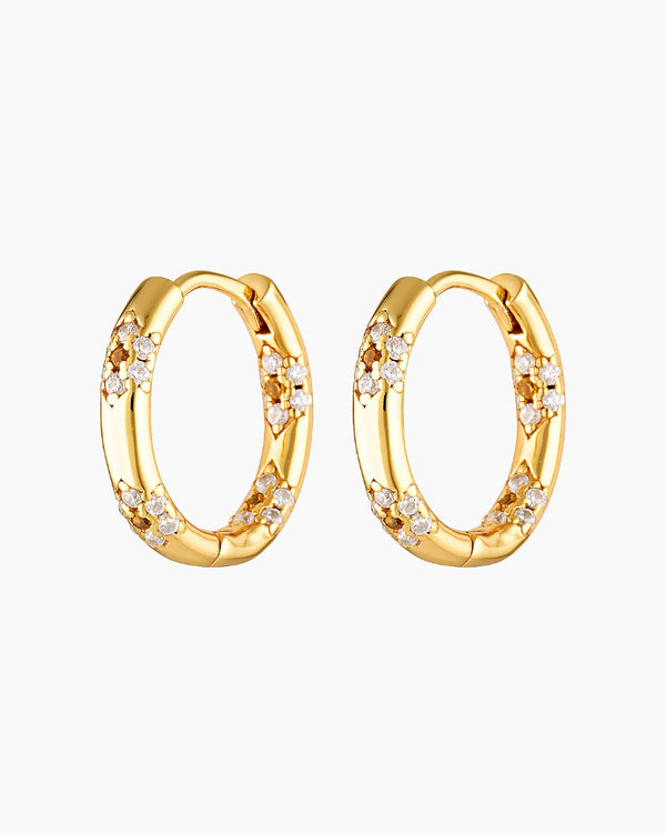 A pair of gold-colored hoop earrings adorned with cubic zirconia stones in a floral pattern.