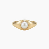 Gold pearl signet ring with a low-profile freshwater pearl, crafted in solid gold with a smooth polished finish and minimalist design.