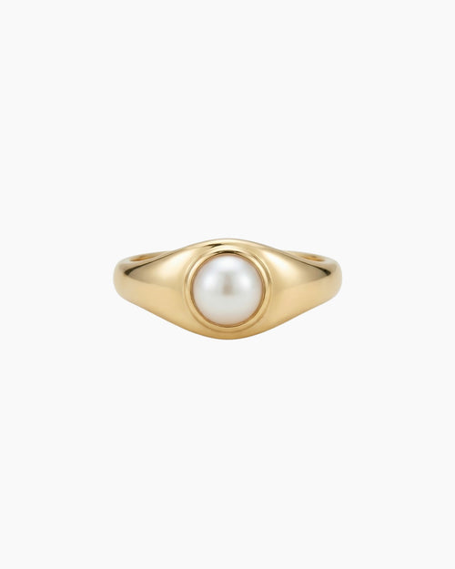 Gold pearl signet ring with a low-profile freshwater pearl, crafted in solid gold with a smooth polished finish and minimalist design.