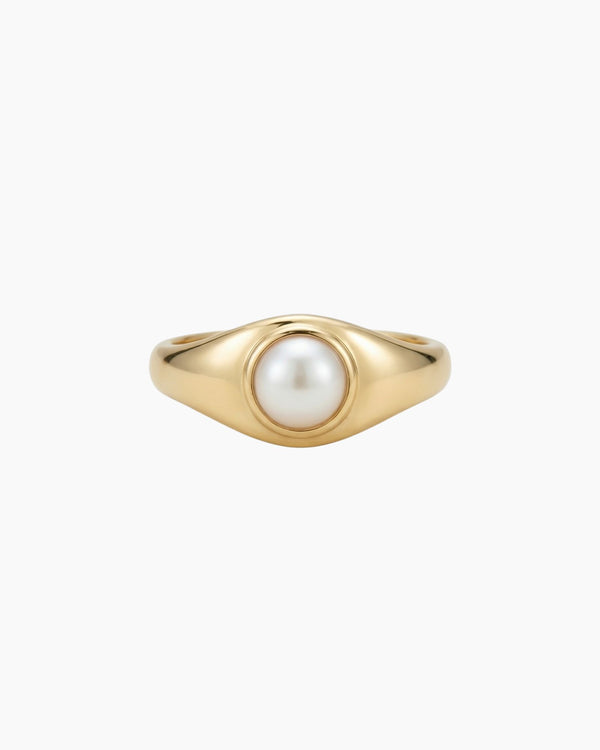 Gold pearl signet ring with a low-profile freshwater pearl, crafted in solid gold with a smooth polished finish and minimalist design.