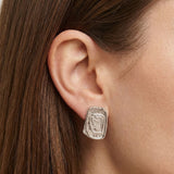Close-up side profile of a woman’s ear wearing a silver statement stud earring with an organic, sculptural rectangular shape and textured surface. Designed for women who want bold yet refined silver jewellery, this image helps customers understand the size, shape, and fit of the silver stud earring for everyday wear or minimalist statement styling.