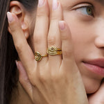 Product image of a woman’s face and hand wearing stacked gold rings, including an organic spiral gold ring and a textured gold band, shown near the ear. Designed for women seeking minimalist gold jewellery for everyday wear, this image demonstrates how stacking gold rings creates a refined, cohesive look while offering versatile styling for daily and elevated outfits.