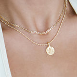 Layered gold necklaces worn on the neck, featuring a slim flat-link gold chain paired with a rope chain and a round gold coin pendant. Styled for women seeking minimalist gold necklaces for everyday wear and layering, offering an effortless solution for building a refined, versatile jewellery stack that elevates simple outfits.
