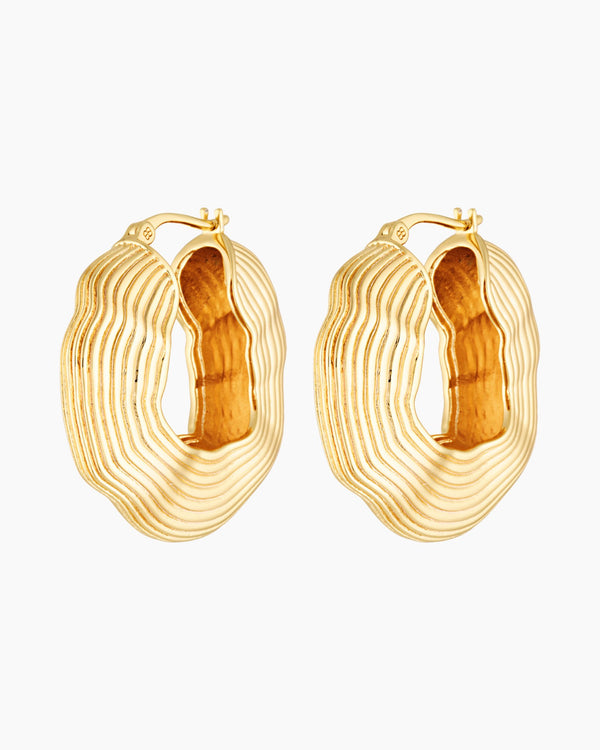 Gold statement hoop earrings with bold sculptural layered texture, 18k gold plated design photographed on a white background.