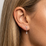 Close-up of a woman wearing sterling silver pearl drop earrings with a delicate chain and marquise-cut cubic zirconia pendant. Demonstrates the size, drop length and fit of lightweight dainty earrings for everyday wear, weddings, events and minimalist jewellery styling.
