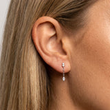 Close-up of a woman wearing sterling silver pearl drop earrings with a delicate chain and marquise-cut cubic zirconia pendant. Demonstrates the size, drop length and fit of lightweight dainty earrings for everyday wear, weddings, events and minimalist jewellery styling.