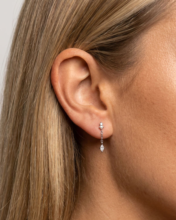 Close-up of a woman wearing sterling silver pearl drop earrings with a delicate chain and marquise-cut cubic zirconia pendant. Demonstrates the size, drop length and fit of lightweight dainty earrings for everyday wear, weddings, events and minimalist jewellery styling.