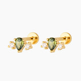 Pair of gold flat back cartilage studs featuring a green pear-cut gemstone with two cubic zirconia accents, 18k gold plated sterling silver, on a white background.