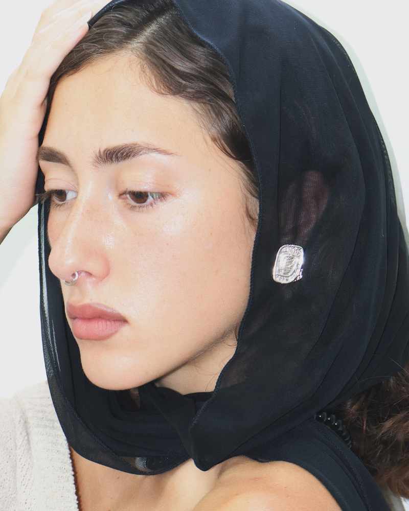 female wearing a silver textured stud earrings 