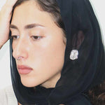 female wearing a silver textured stud earrings 