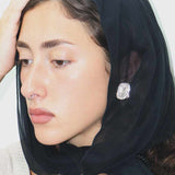 female wearing a silver textured stud earrings 