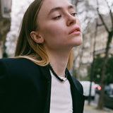 model wearing black beaded onyx necklace with silver and white baroque pearl in the middle