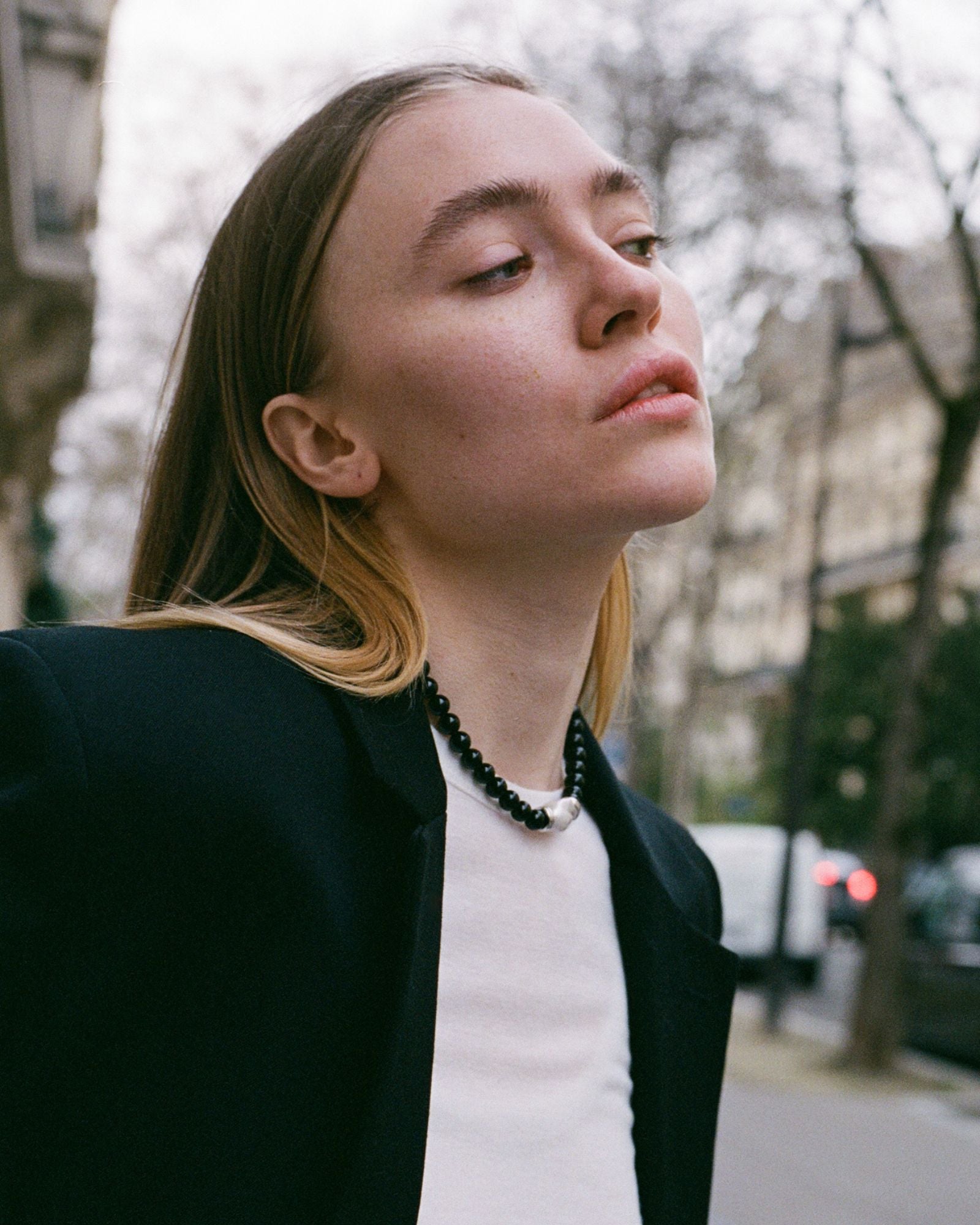 model wearing black beaded onyx necklace with silver and white baroque pearl in the middle