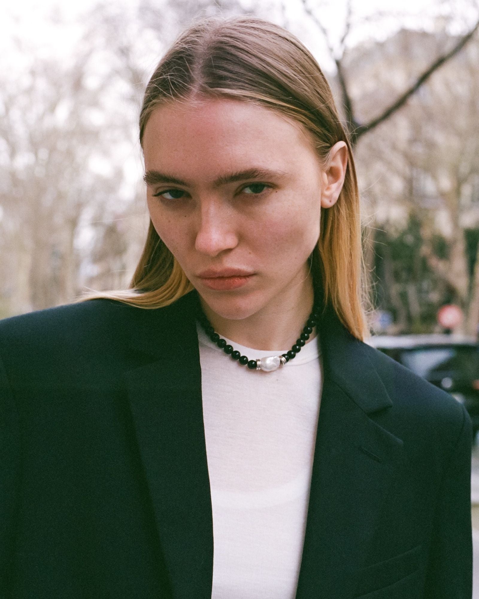 black beaded onyx neckalce with silver details with a white natural baroque pearl as a centerpiece 