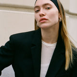 Model wearing the silver Sofia Necklace with dainty cubic zirconia pendant layered over a black blazer.