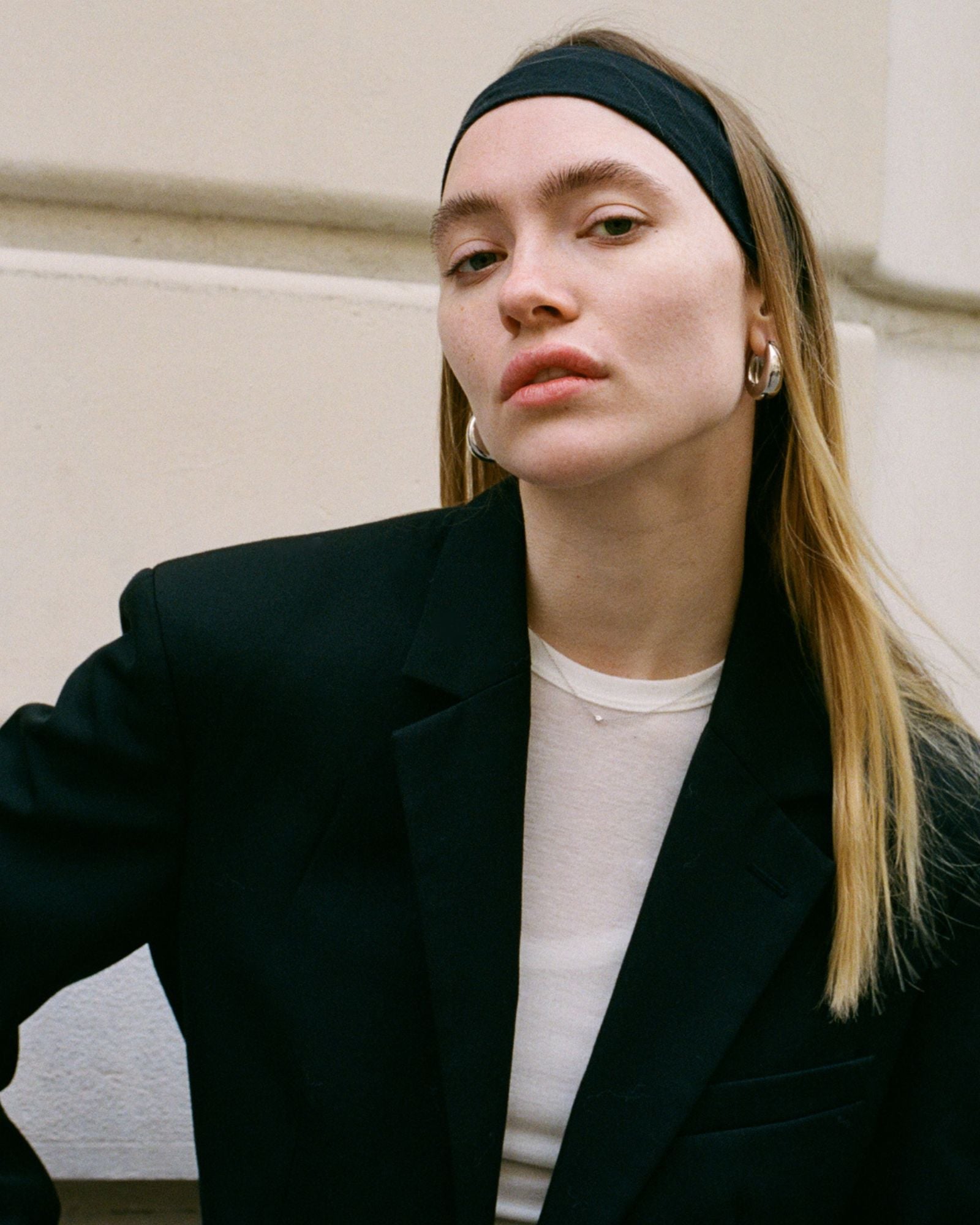 Model wearing the silver Sofia Necklace with dainty cubic zirconia pendant layered over a black blazer.