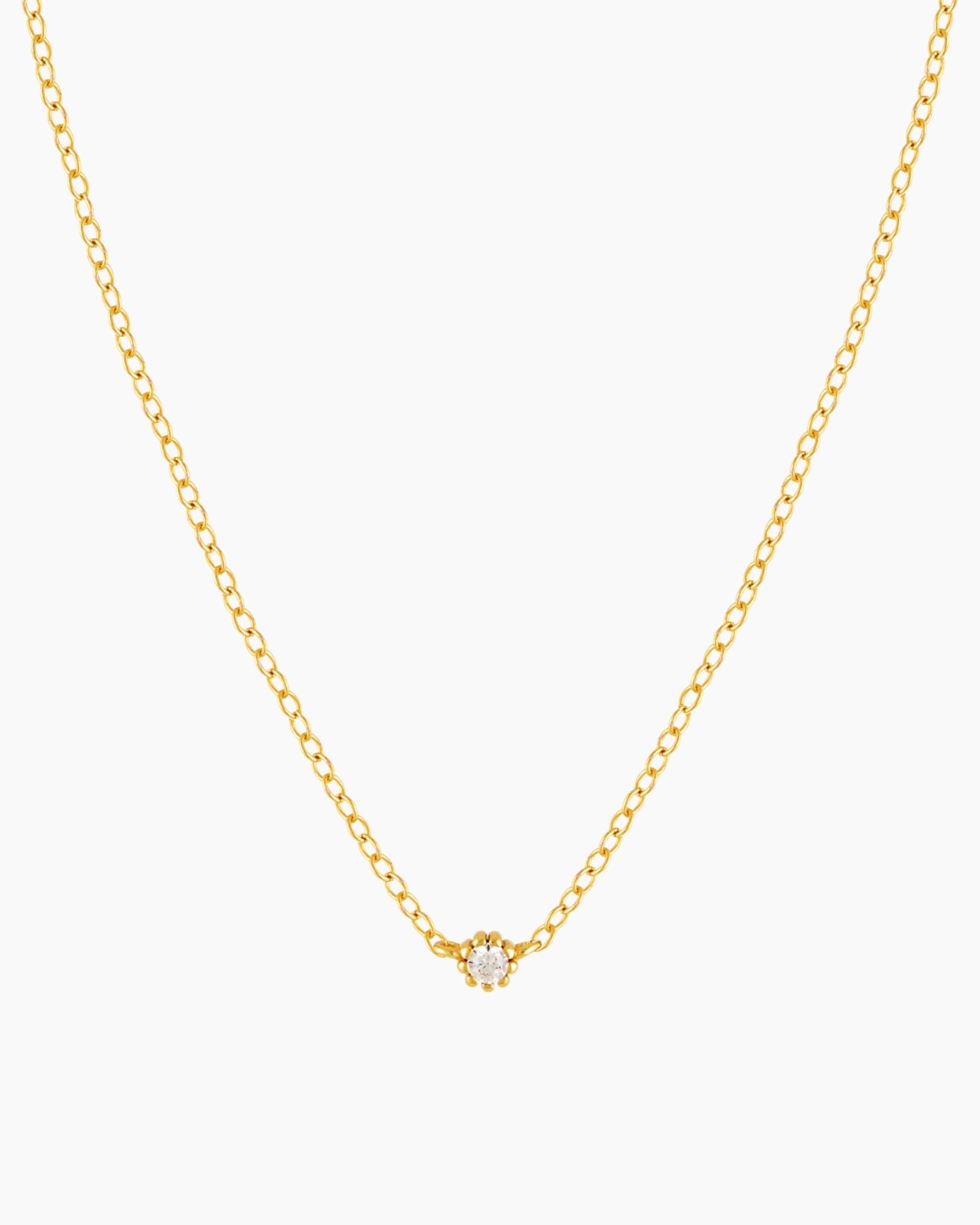 Dainty gold necklace with small cubic zirconia stone on a thin rolo chain