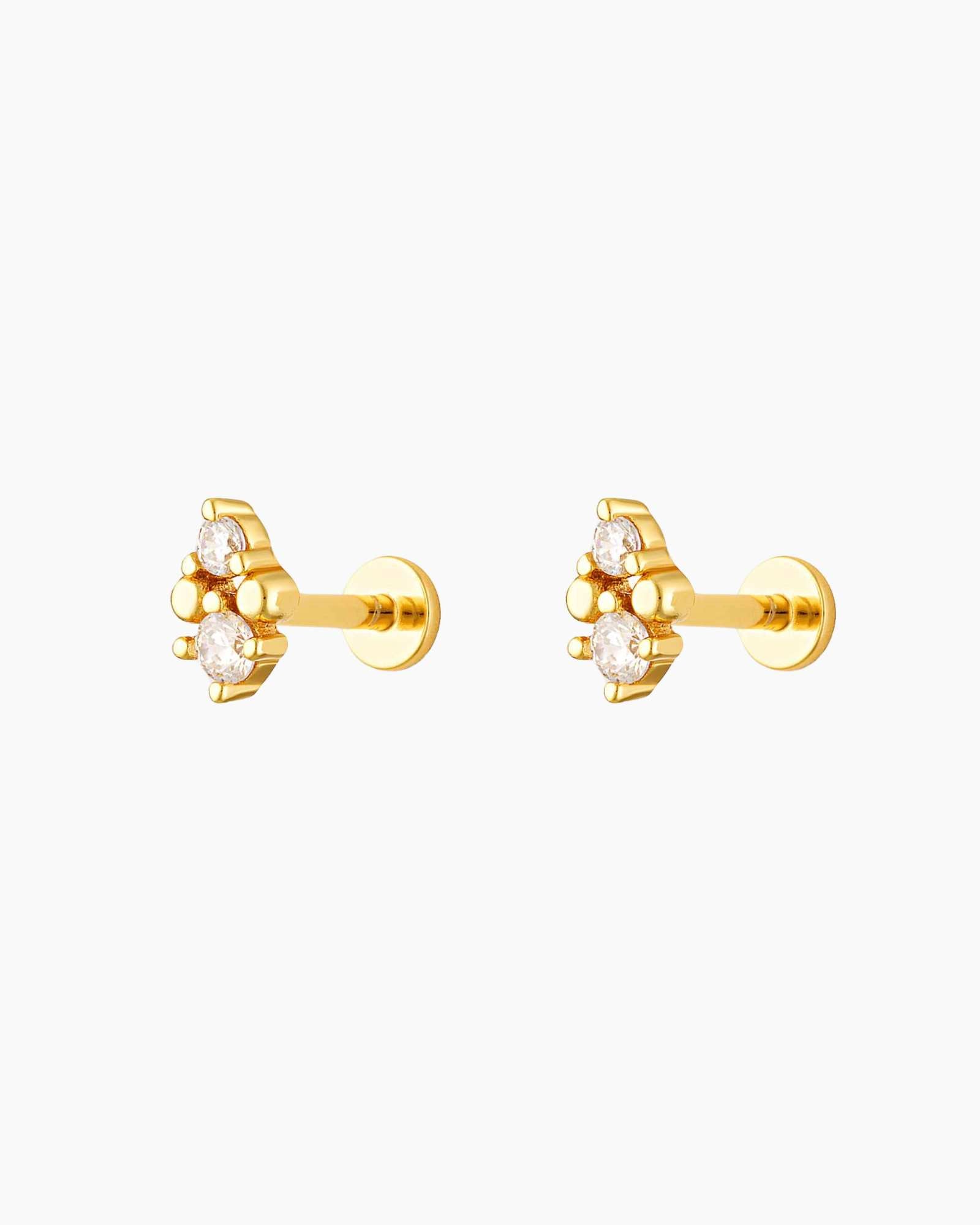 gold flat back ear piercing with two white gemstones
