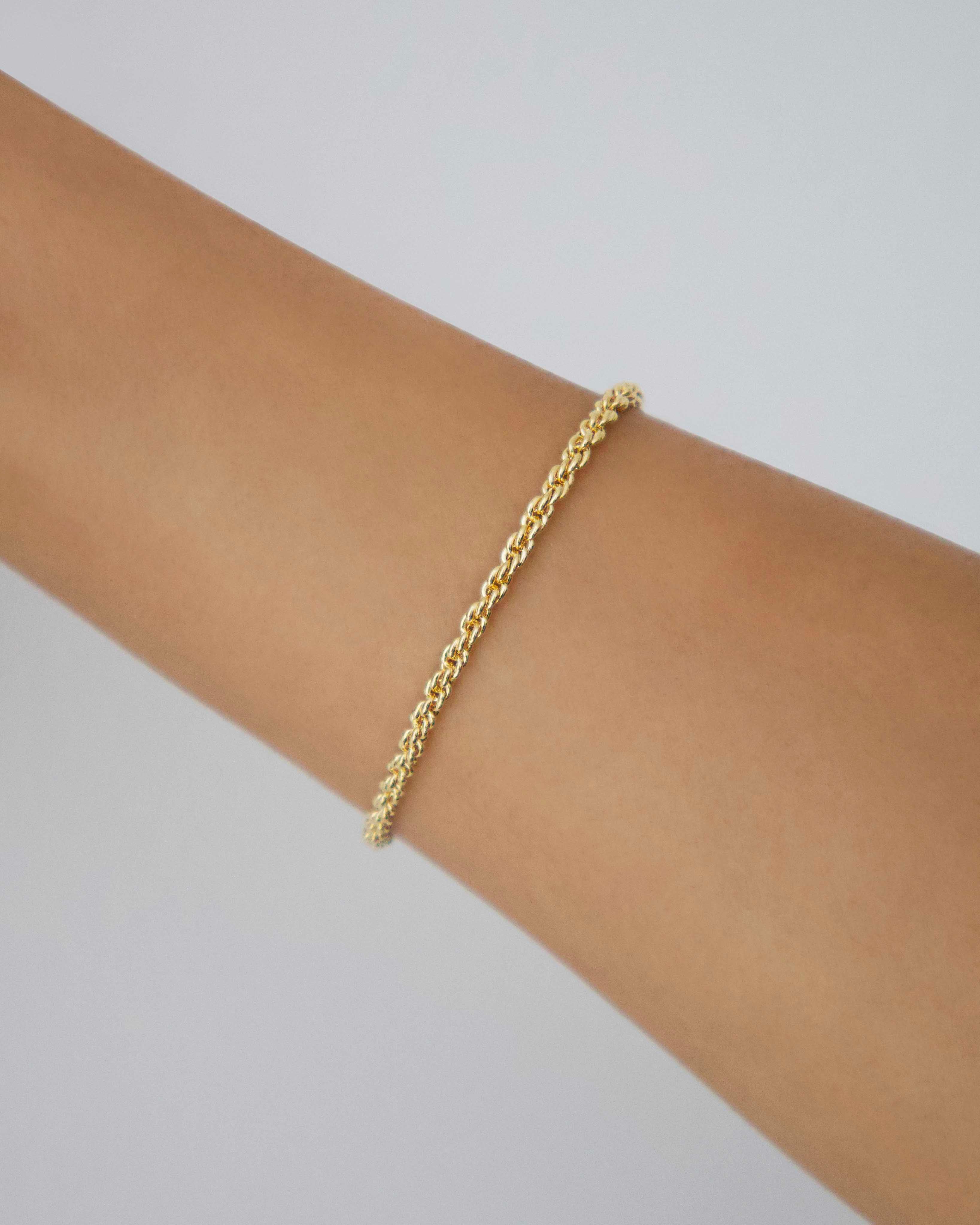 Gold-filled rope chain bracelet shown on wrist, minimal fine jewellery piece photographed against a soft neutral background.