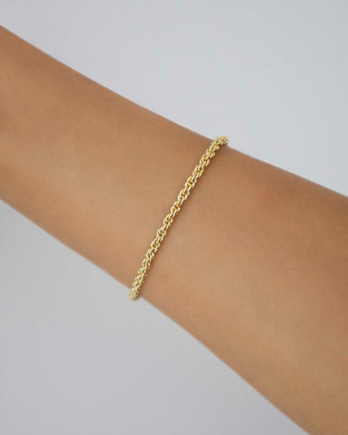 Gold-filled rope chain bracelet shown on wrist, minimal fine jewellery piece photographed against a soft neutral background.