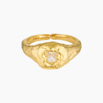 Close-up product image of a gold filled ring featuring a textured organic band with a central clear crystal set in a raised bezel on a white background. This image is for women looking for an everyday gold ring that adds subtle statement detail and offers a refined alternative to smooth minimalist bands.