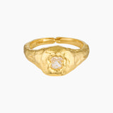 Close-up product image of a gold filled ring featuring a textured organic band with a central clear crystal set in a raised bezel on a white background. This image is for women looking for an everyday gold ring that adds subtle statement detail and offers a refined alternative to smooth minimalist bands.